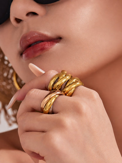 Gold chunky double ring worn on hand with sculptural interlocking band for statement jewelry collections