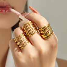 Model wearing chunky gold tone 316L stainless steel open rings in multiple designs