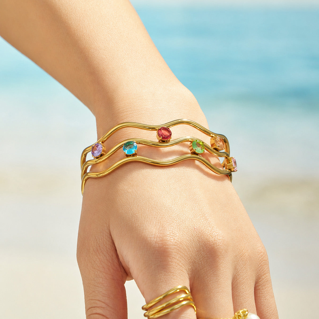 Gold clear cubic zirconia open bangle styled on the wrist