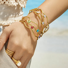 Model wearing a gold three-layer open bangle with clear cubic zirconia
