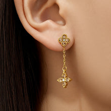 Model wearing gold four-leaf clover cubic zirconia drop earrings