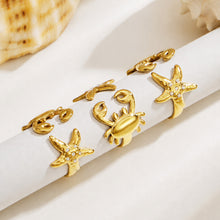 Gold crab and starfish open rings displayed together on a light background for coastal jewelry styling