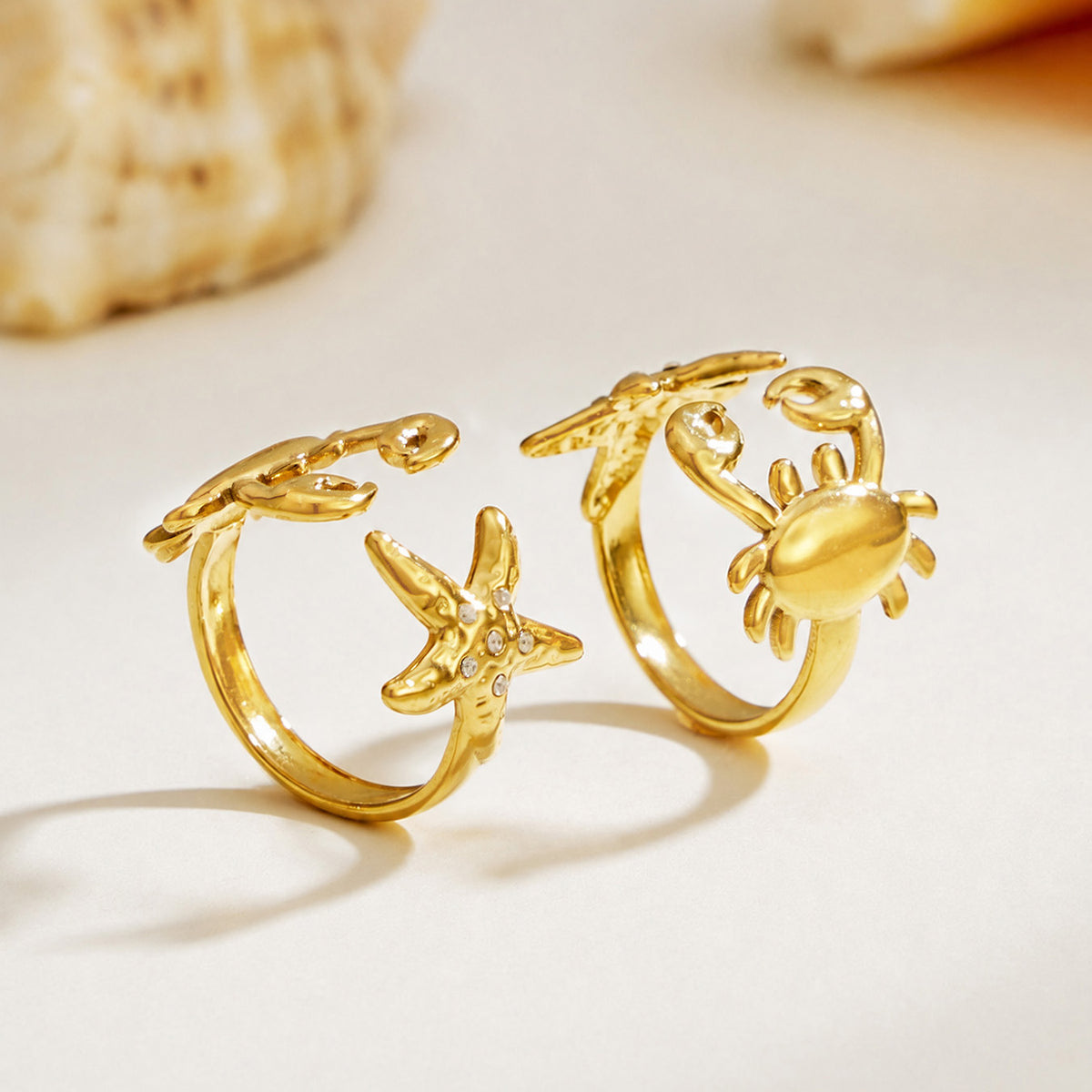 Gold crab and starfish ring designs displayed on a clean white surface with 18K PVD gold finish
