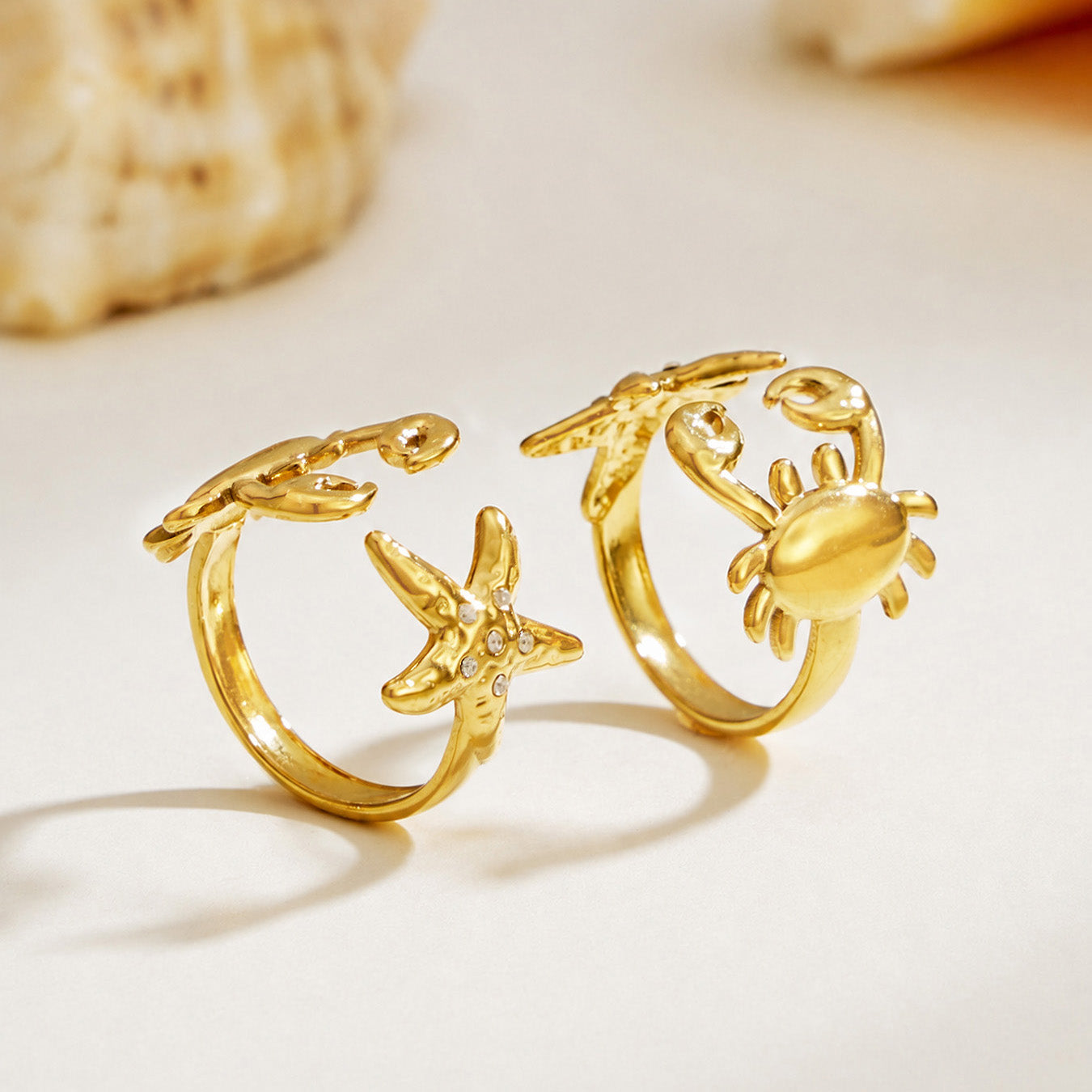 Gold crab and starfish ring designs displayed on a clean white surface with 18K PVD gold finish