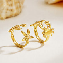 Gold crab and starfish ring designs displayed on a clean white surface with 18K PVD gold finish