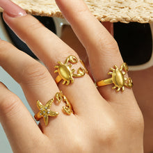 Model wearing gold crab and starfish rings in 316L stainless steel for a playful coastal jewelry look
