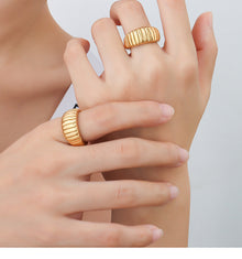 Model wearing two gold croissant dome rings with French-inspired ribbed texture for bold ring styling
