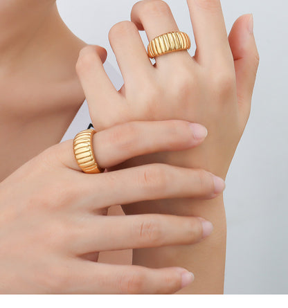Model wearing two gold croissant dome rings with French-inspired ribbed texture for bold ring styling