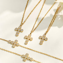 Three gold cross zircon pendant necklaces arranged on a light neutral background