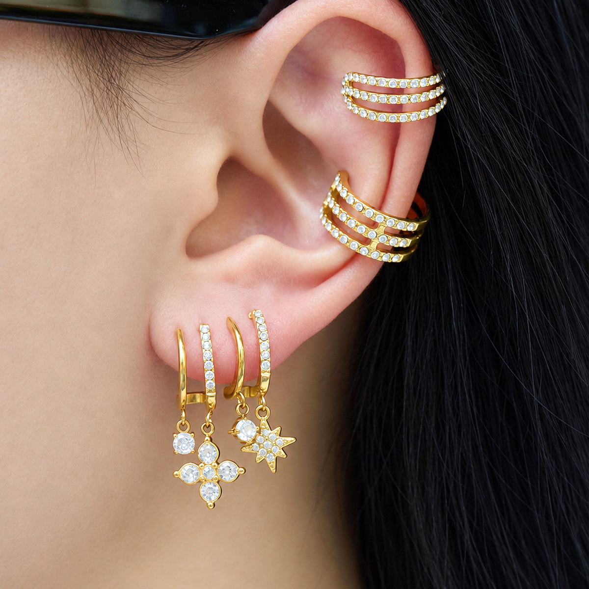 Gold-tone stainless steel CZ charm drop earrings styled on ear
