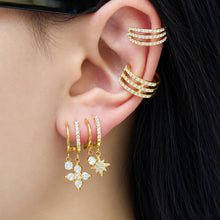 Gold-tone stainless steel CZ charm drop earrings styled on ear