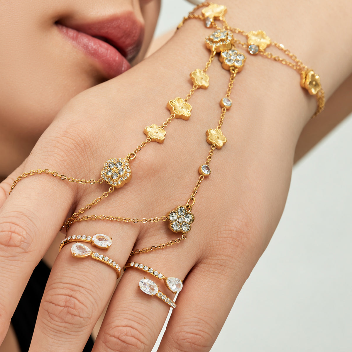 Gold-tone stainless steel flower hand chain bracelet with cubic zirconia styled on hand
