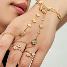 Gold-tone stainless steel flower hand chain bracelet with cubic zirconia styled on hand
