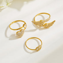Gold 316L stainless steel heart and geometric CZ rings arranged in a clean flat lay