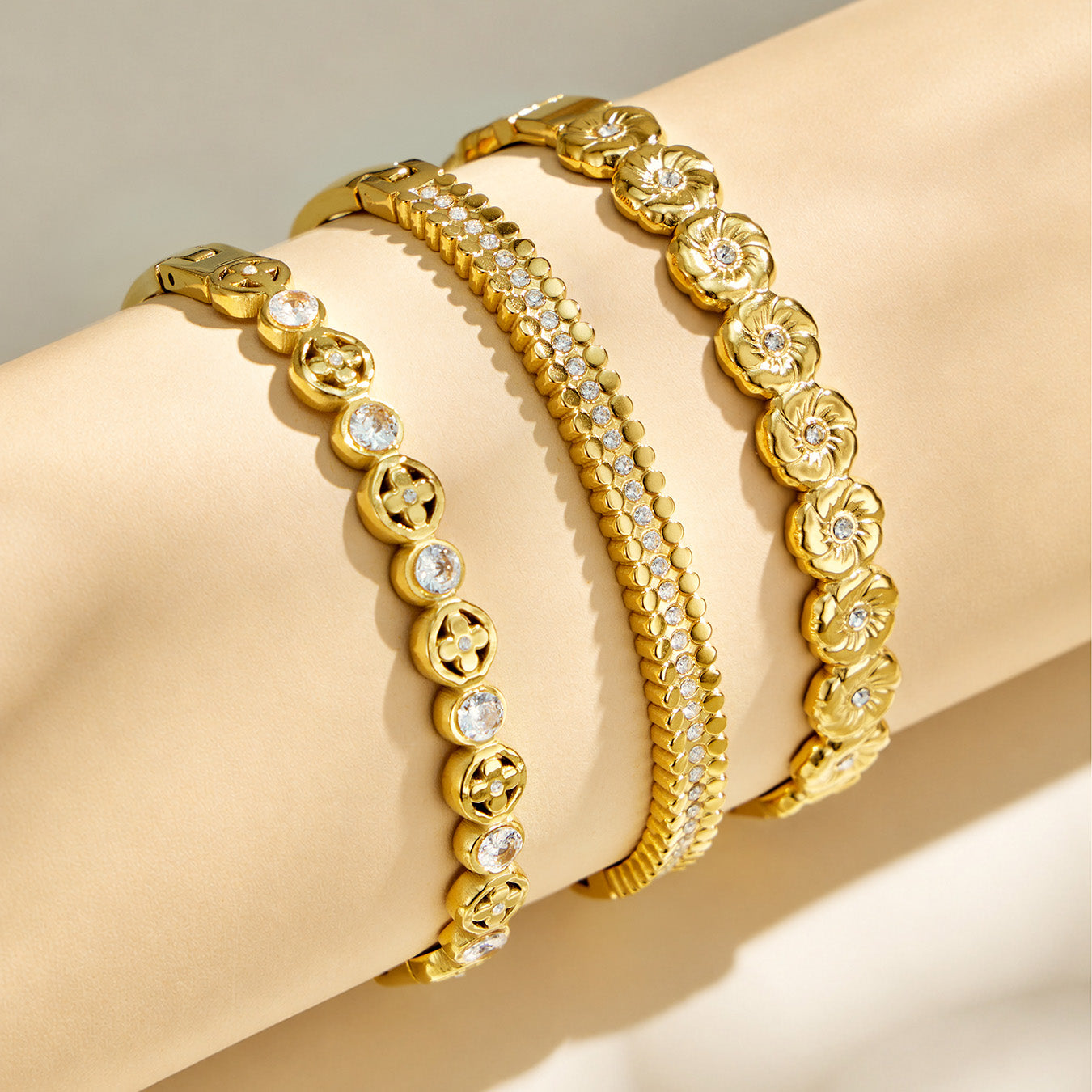 Model wearing layered gold cubic zirconia hinged bangle bracelets