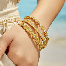 Hand close-up of layered gold cubic zirconia hinged bangle bracelets