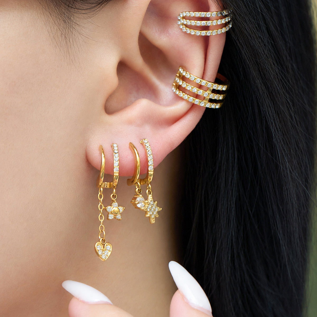 Gold-tone stainless steel long drop earrings with cubic zirconia charms worn on ear