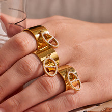Gold CZ open rings stacked on hand with wide band and pendant details for boutique ring assortments