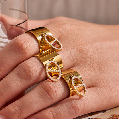 Gold CZ open rings stacked on hand with wide band and pendant details for boutique ring assortments