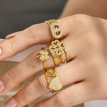 Multiple 18K PVD gold cubic zirconia open rings styled together on a model hand