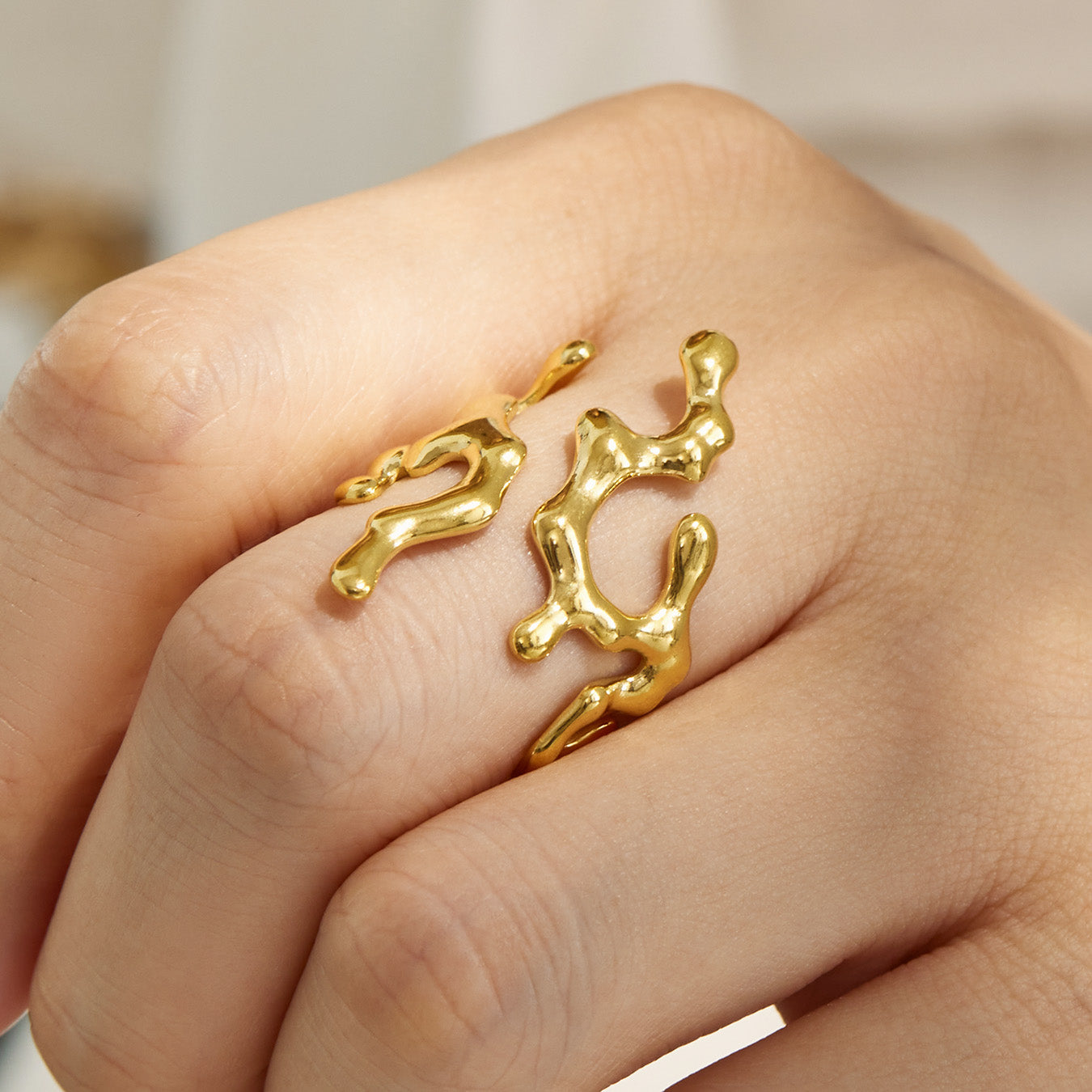 Gold 316L stainless steel sculptural open ring with cubic zirconia accent worn on hand