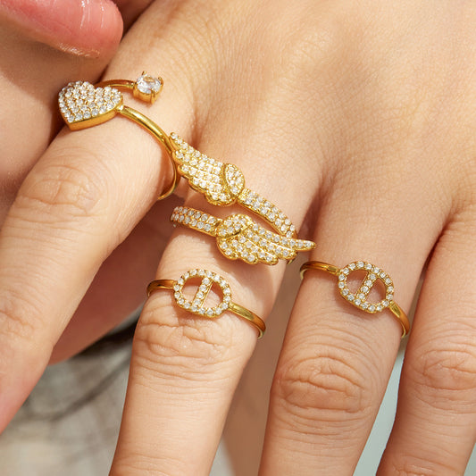 Model wearing multiple 316L stainless steel CZ statement rings in 18K PVD gold