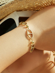Close up of gold D-shaped zircon bracelet worn on wrist with 316L stainless steel geometric charm details