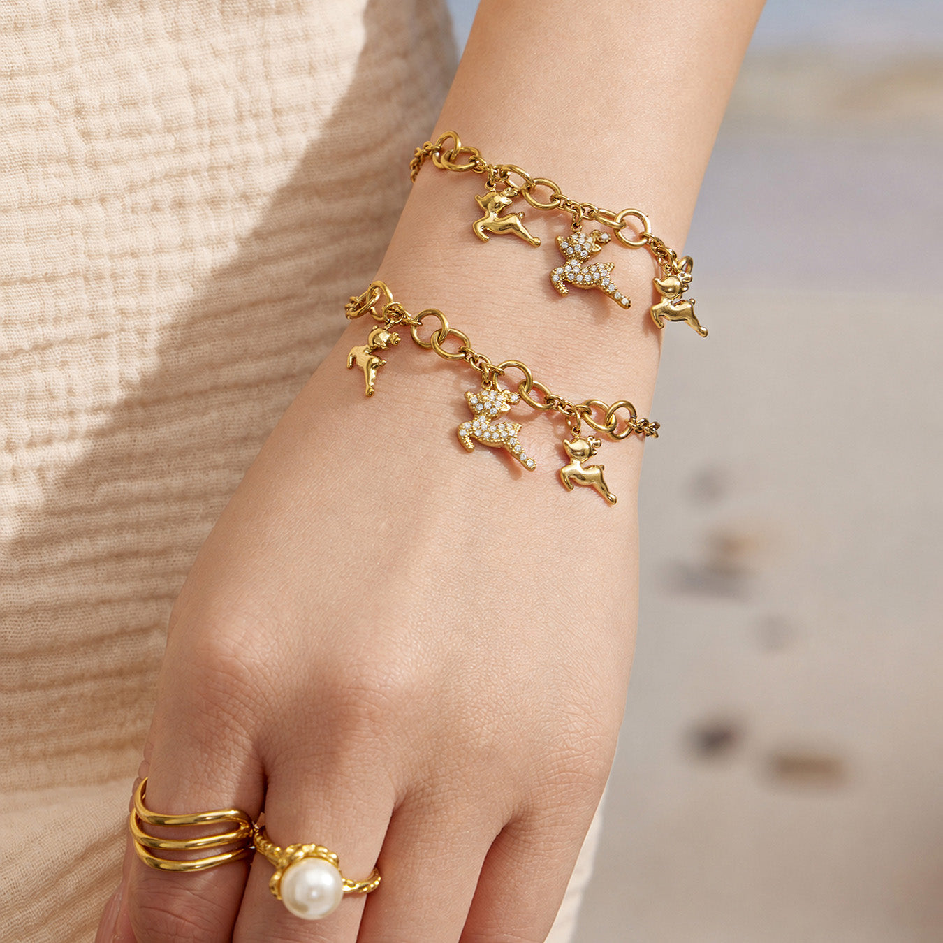 Gold deer charm bracelet with a zircon reindeer centerpiece worn on the wrist