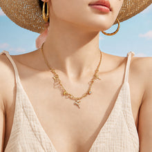 Close-up portrait of a model wearing a delicate gold deer pendant necklace