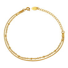 Gold double layer bracelet with a snake chain and bead chain shown in a clean flat lay product photo
