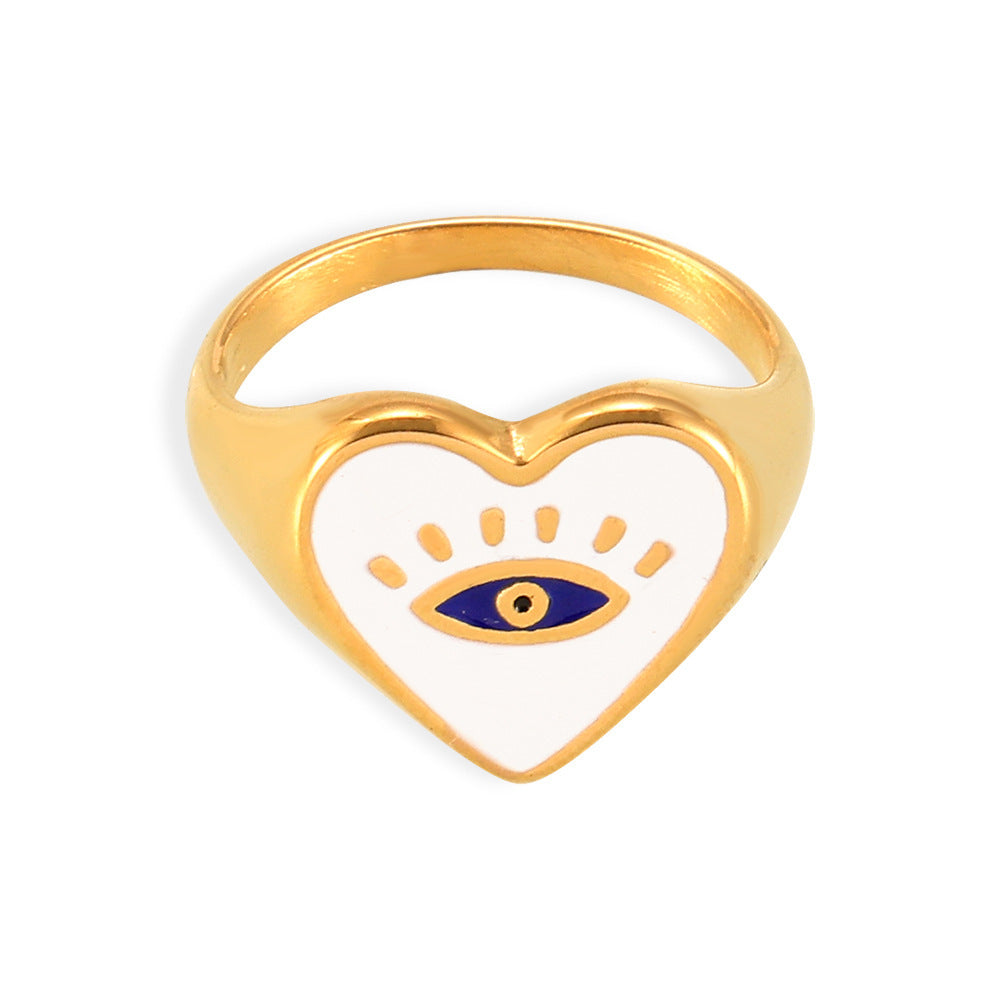 Gold-tone stainless steel evil eye heart ring with a white heart face and blue eye motif