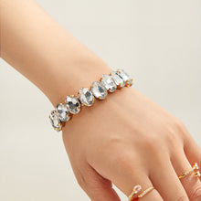 Gold-tone stretch bracelet with clear faceted glass rhinestones styled on hand