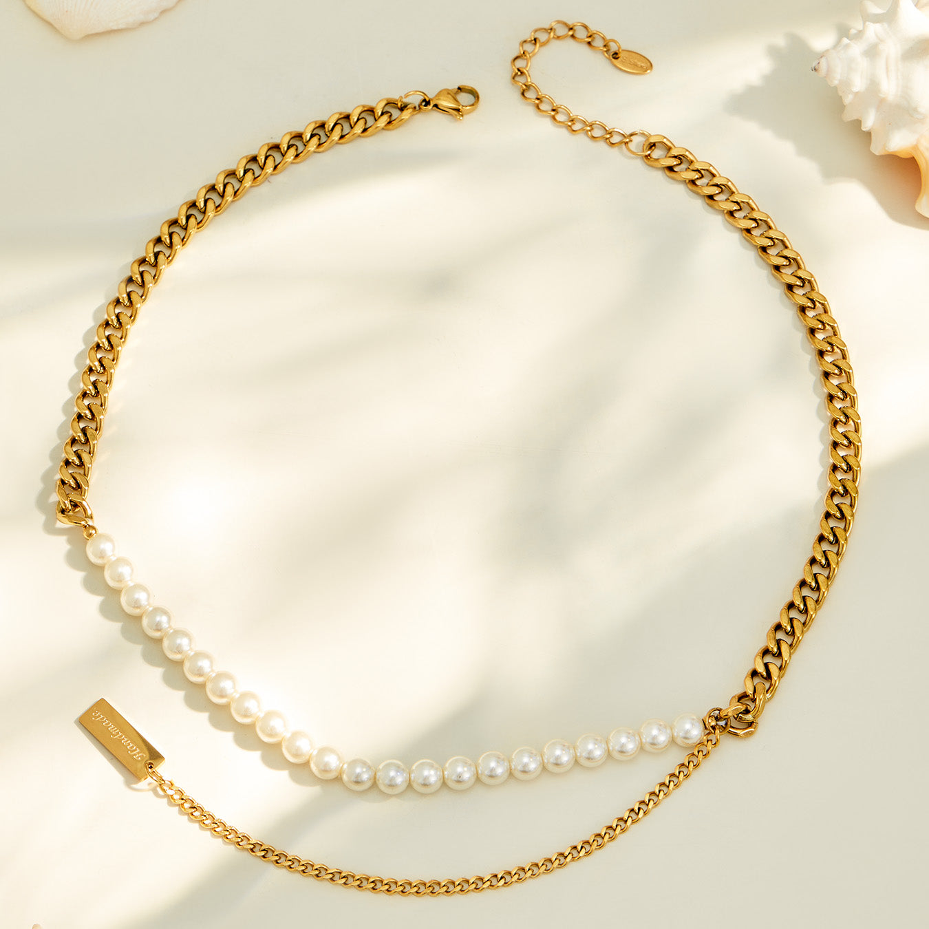Gold faux pearl necklace arranged in a circular flat lay on soft cream fabric
