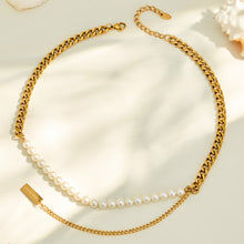 Gold faux pearl necklace arranged in a circular flat lay on soft cream fabric