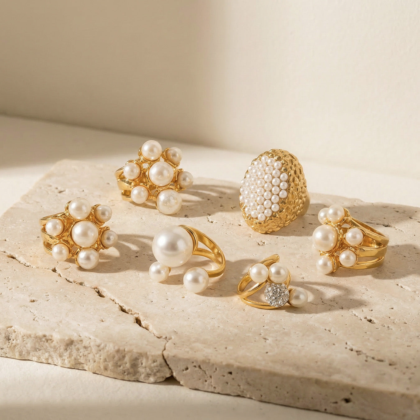 Gold faux pearl ring assortment displayed on a neutral jewelry stand