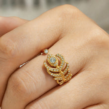 Gold tone feather-inspired statement open ring shown on a model finger