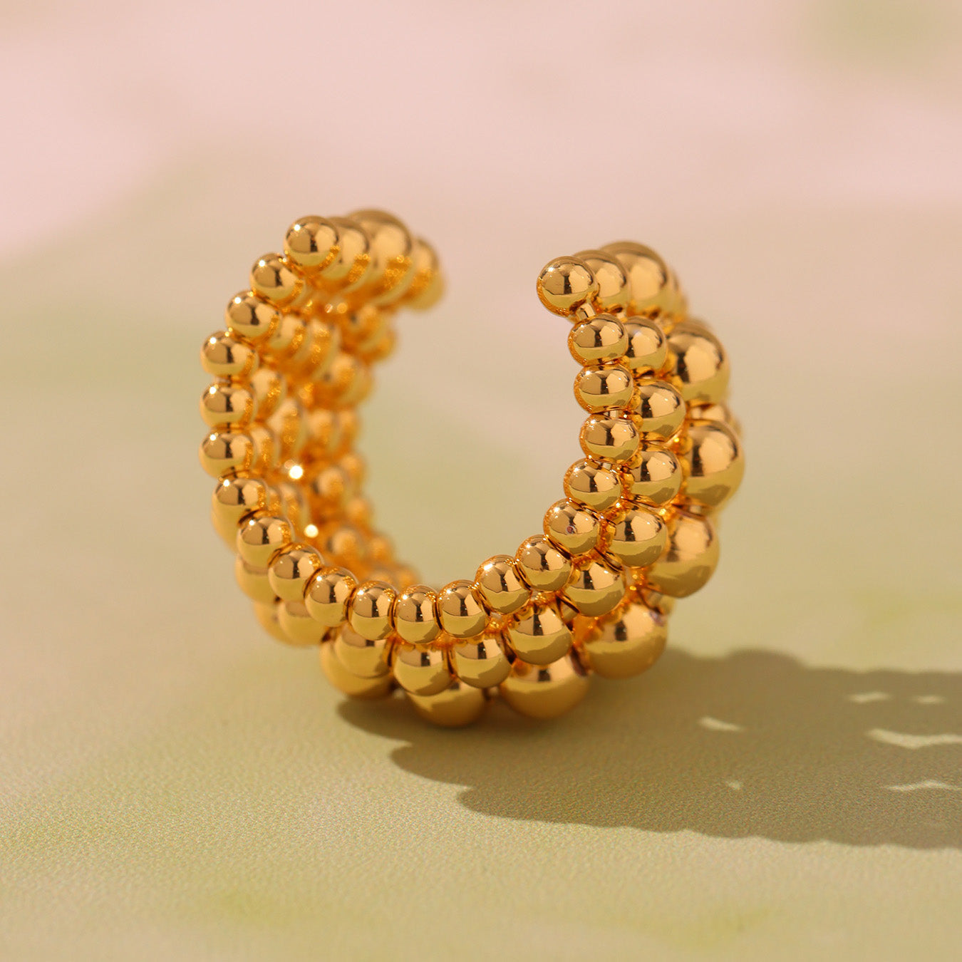Front view of gold tone five-row beaded stainless steel statement ring