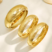 Close-up detail of a gold floral engraved bangle surface