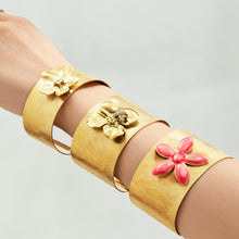 Gold flower cuff bangles with floral and pink flower details styled together