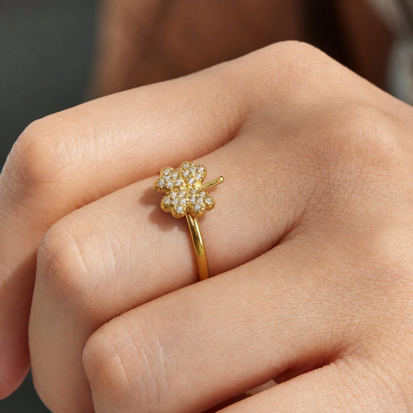 Close-up of a model wearing a gold floral cubic zirconia open ring in 316L stainless steel