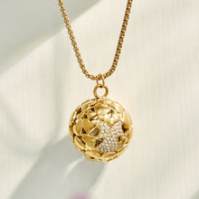 Gold floral medallion pendant necklace displayed on a soft neutral background