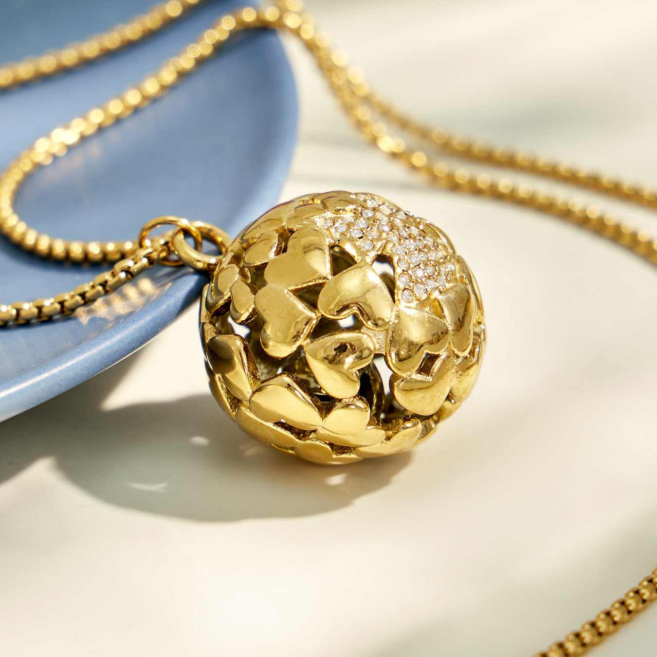 Close-up of a gold textured floral medallion pendant with clear zircon accents