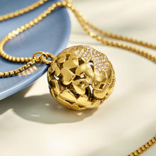 Close-up of a gold textured floral medallion pendant with clear zircon accents
