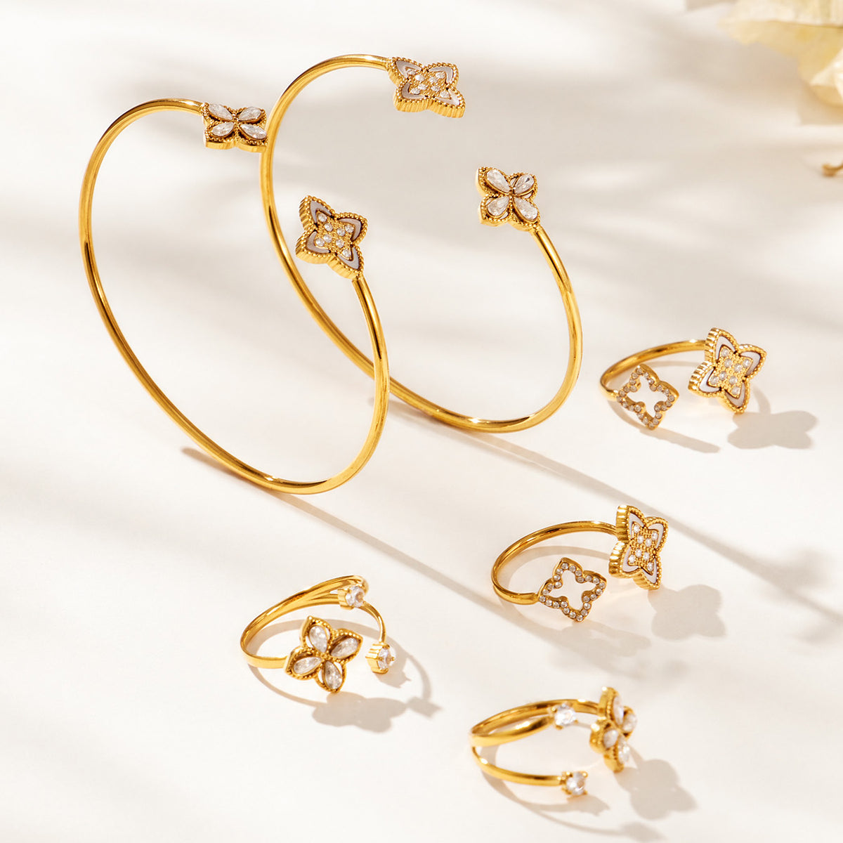 Assorted gold-tone floral open rings and bangles displayed together