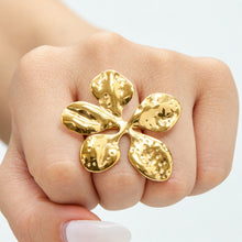 Gold floral statement ring with hammered metal petals shown close up