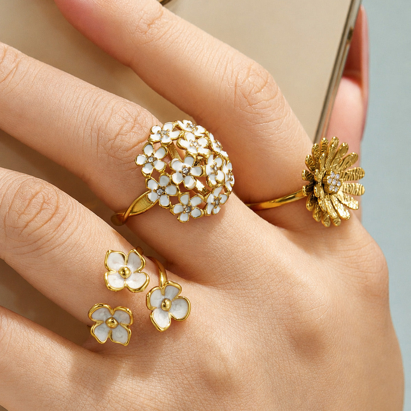 Model wearing 316L stainless steel floral statement rings with CZ and enamel flower details