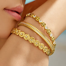 Model wearing gold floral and striped cubic zirconia hinged bangles together