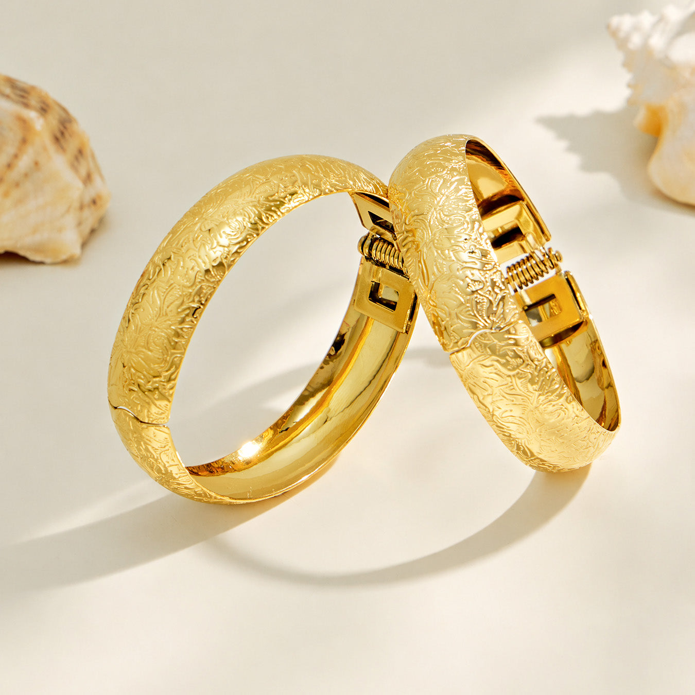 Side view of a gold floral engraved wide bangle