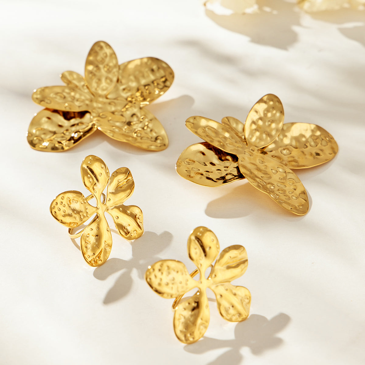 Matching gold flower earrings and rings with hammered stainless steel design