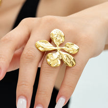 Gold flower ring with hammered statement design worn on finger
